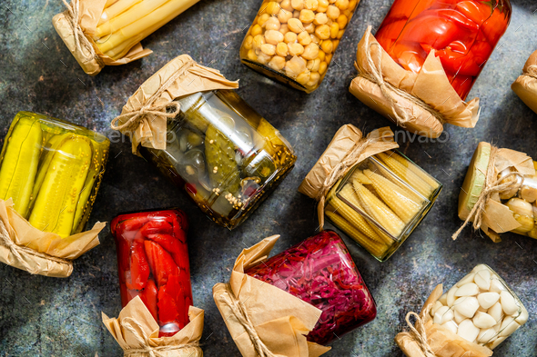 Preservation of vegetables in glass jars. Tomatoes, cucumbers, mushrooms, cabbage, pepper - Stock Photo - Images
