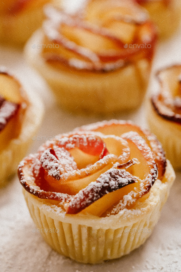 Apple rose puff pastries sprinkled with powdered on baking paper - Stock Photo - Images