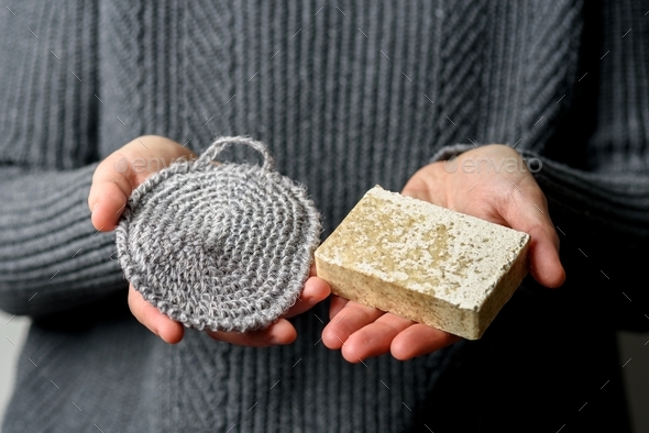 Hand holding jute wash cloth with soap