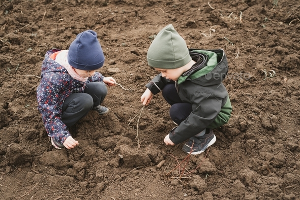 Children explore the earth in early spring.