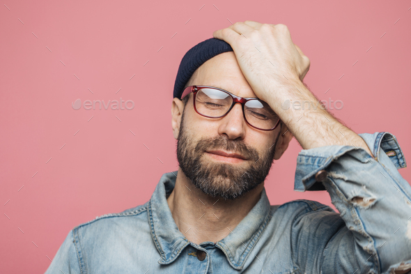 Portrait of depressed middle aged unshaven male closes eyes and keeps ...