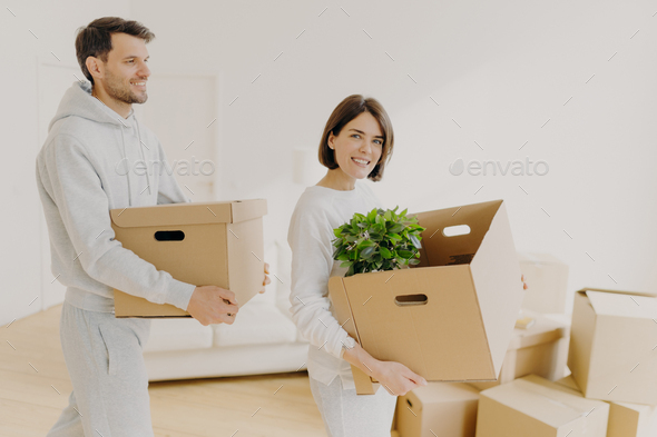 Photo of family couple carry big boxes with households items and personal belongings