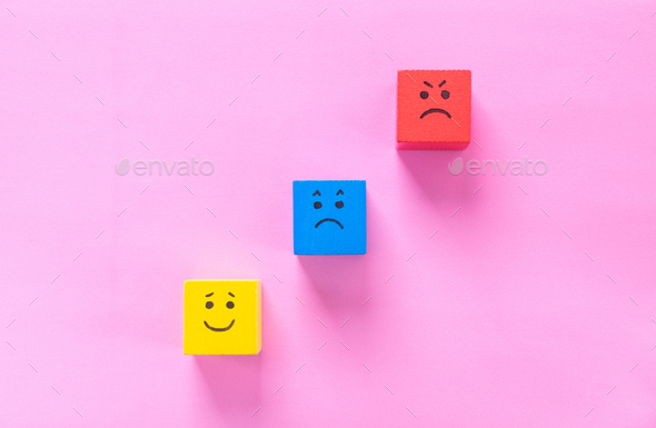 Red, blue and yellow cubes with cute faces depicting human emotions: anger, sadness and happiness