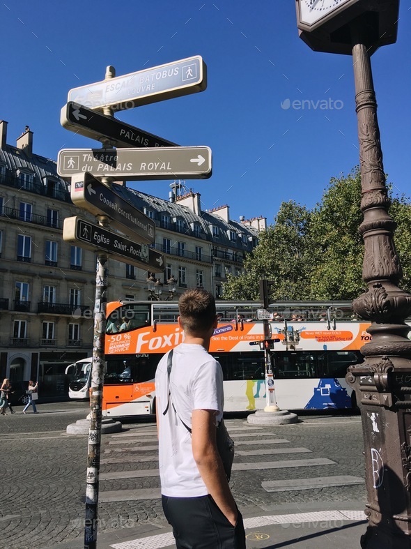 Street signs in Paris on the background of moving bus and a guy is going to across the street
