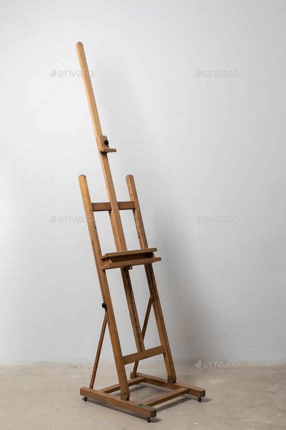 A large easel standing in an art studio against a white wall