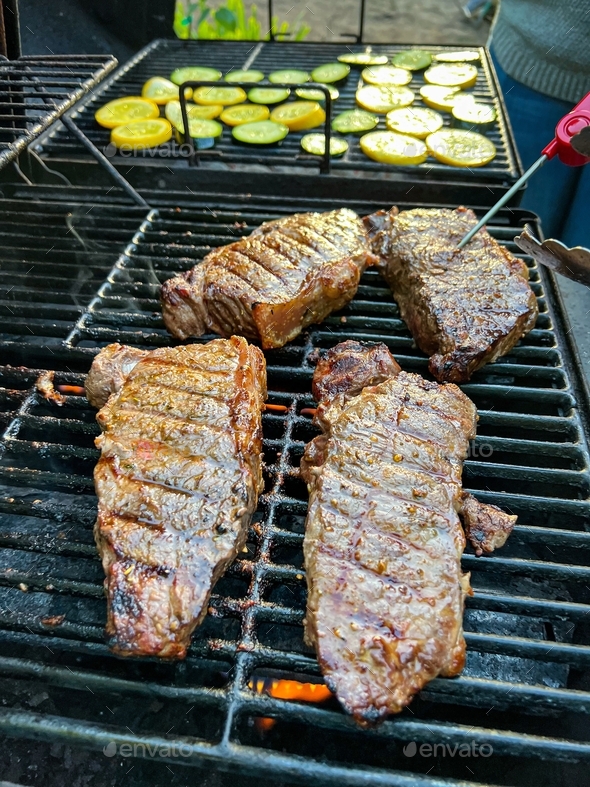 Measuring temperature on medium rare New York Strip Steak on grill with