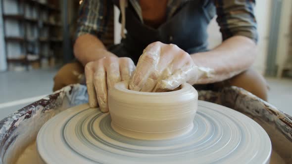 Close-up of Male Potter's Hands Manufacturing Ceramic Bowl From Clay Using Throwing Wheel alt