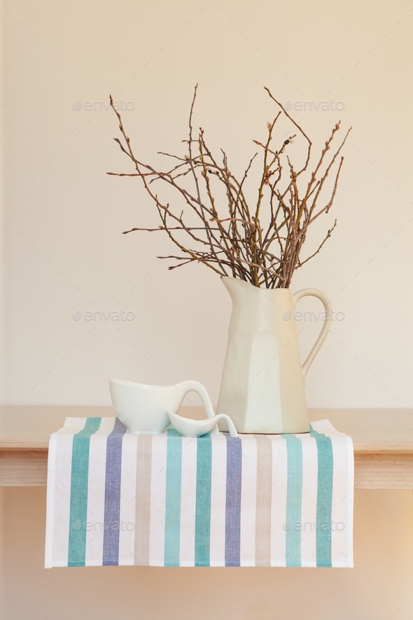Elegant minimalistic still life, dishes on tablecloth or napkins with jug with branches
