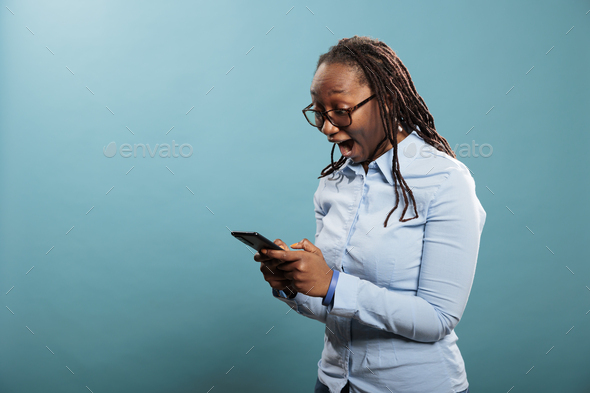 Cheerful excited african american person with smartphone device surprised by received email.