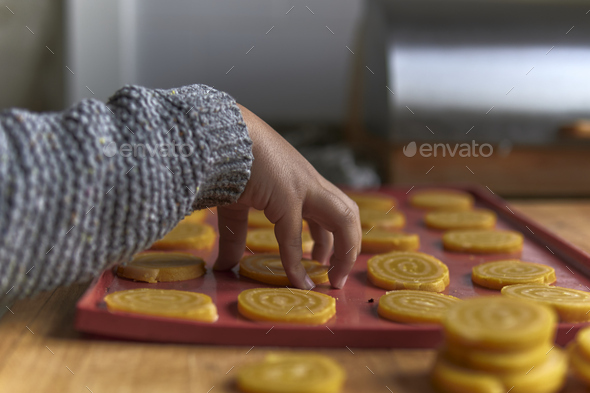 elementary age boy placing cookies on a silicone tray - Stock Photo - Images