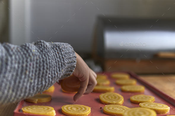 elementary age boy placing cookies on a silicone tray - Stock Photo - Images