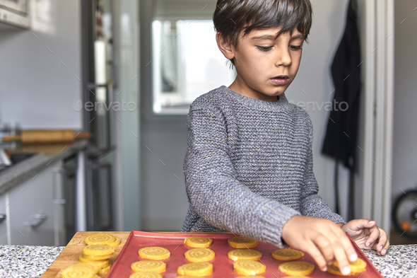 elementary age boy making cookies in wintertime - Stock Photo - Images