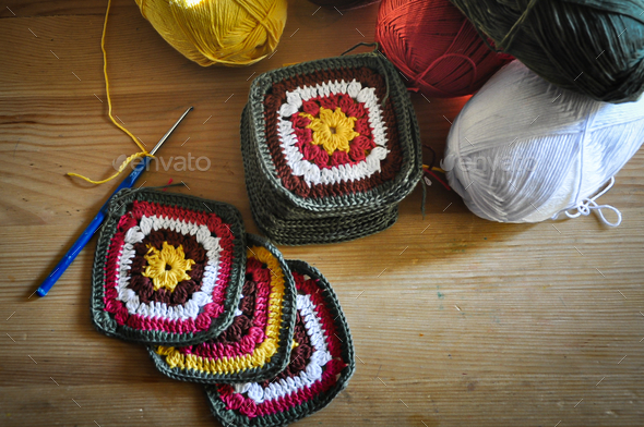 The details are crocheted with their own hands, multicolored yarn lies on a  wooden table Stock Photo by Yashik7777