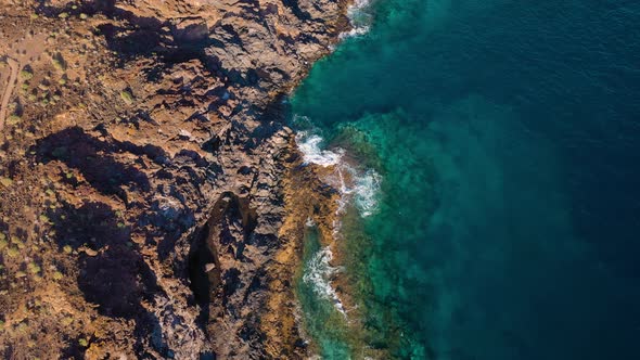 Top View of a Deserted Coast. Rocky Shore of the Island of Tenerife. Aerial Drone Footage of Ocean alt
