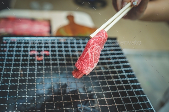 Close up of Piece of raw sliced beef on charcoal grill at Outdoor party. outdoor recreation