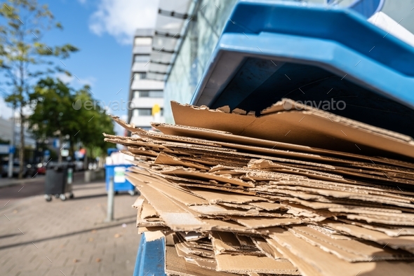 Used cardboard boxes to be collected in a plastic container for paper waste separation recycling.