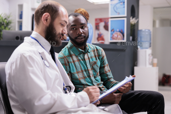 Man explaining symptoms to doctor in consultation