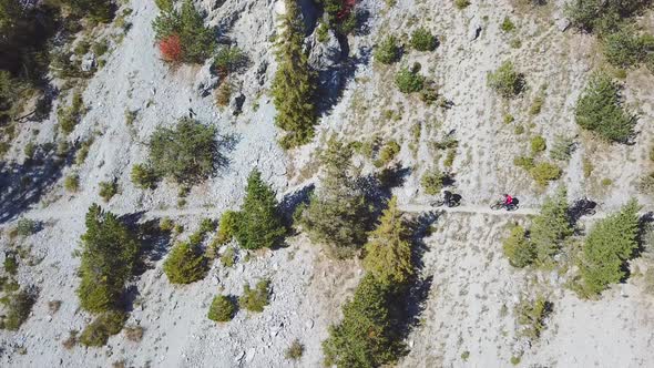 Aerial drone view of a group of mountain bikers on a singletrack trail alt