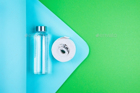 Sport mat and yoga belt, water in glass bottle