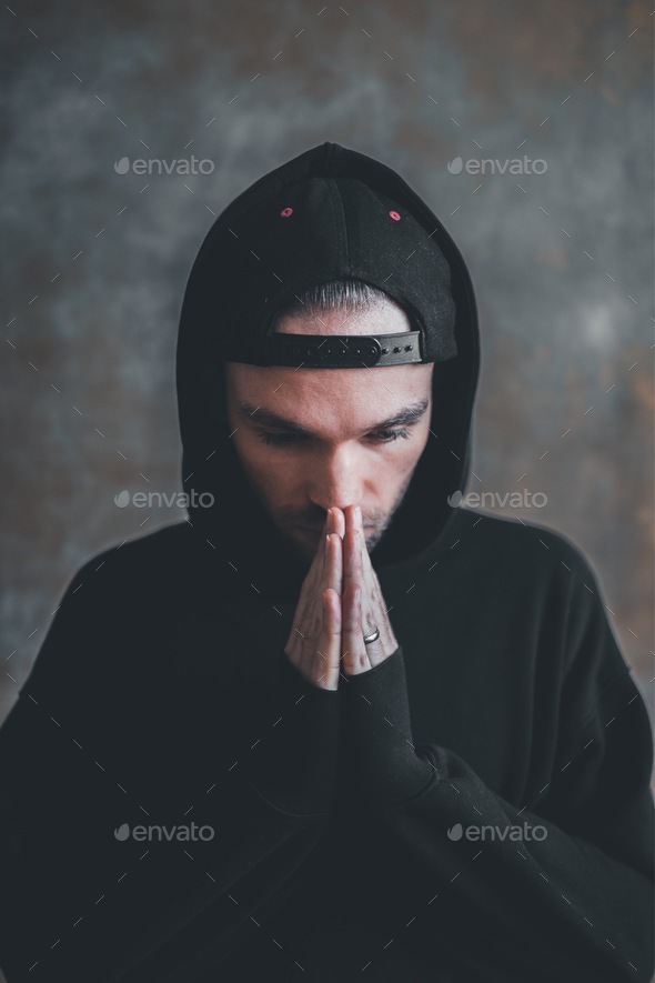 Portrait of a man praying infront of the wall
