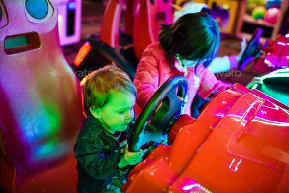 toddler playing at the video game car - Stock Photo - Images