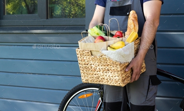 Fresh organic bread, vegetables, greens and fruits, cereals and pasta in a wicker basket