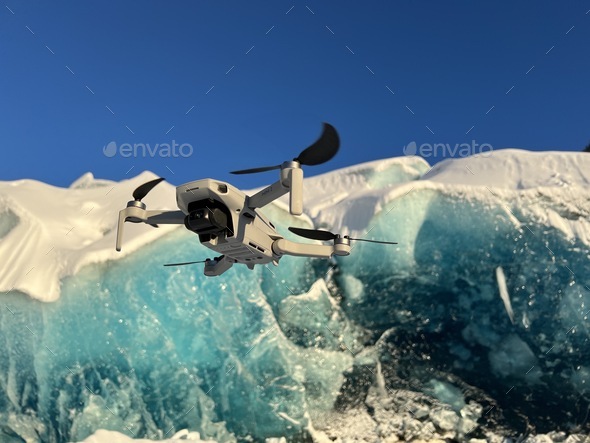 Dji mini 2 drone flying outdoors in front of glacier modern technology