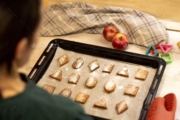 Homemade geometric shaped cookies sprinkled with powdered sugar on a baking sheet