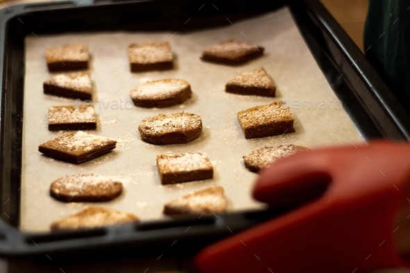 Homemade geometric shaped cookies sprinkled with powdered sugar on a baking sheet