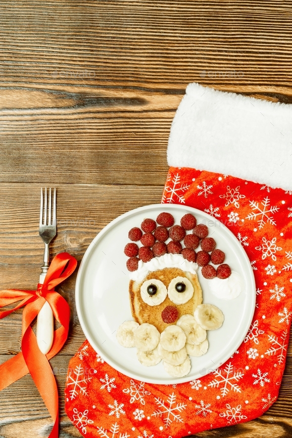 Christmas Santa Claus face shaped pancake with sweet fresh raspberry