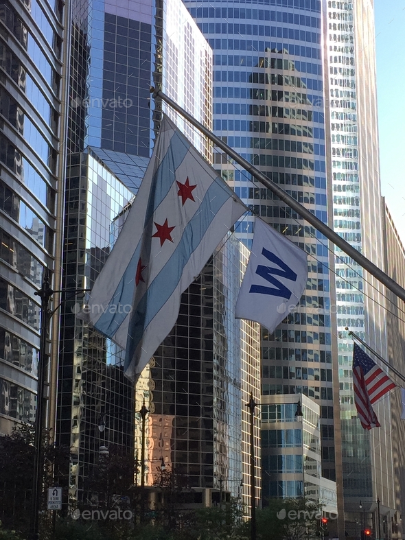 The chicago flag, the american flag, and the chicago cubs w flag on display in chicago