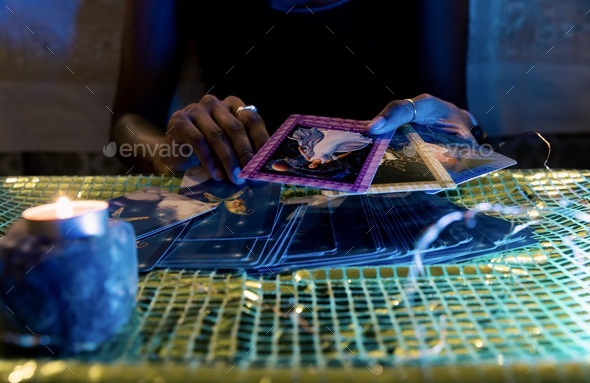 A woman’s hands picking out cards for an oracle card session
