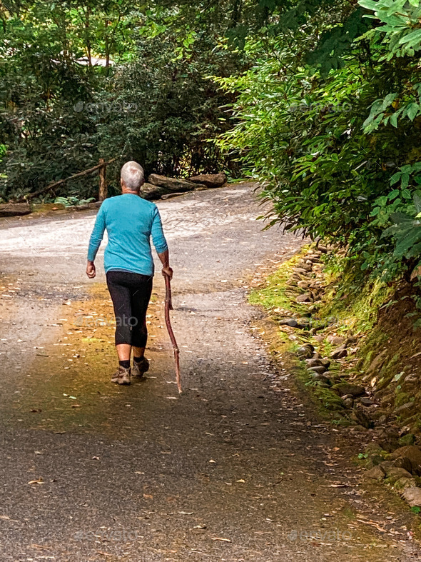 Woman walking in nature which helps with positive mental health issues. Psychology.