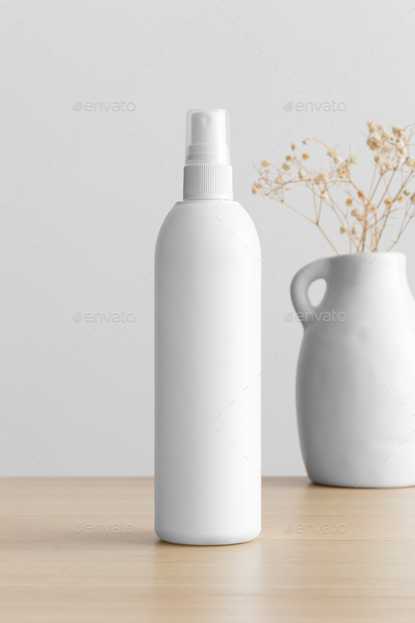 White cosmetic spray bottle mockup with a gypsophila on the wooden table.