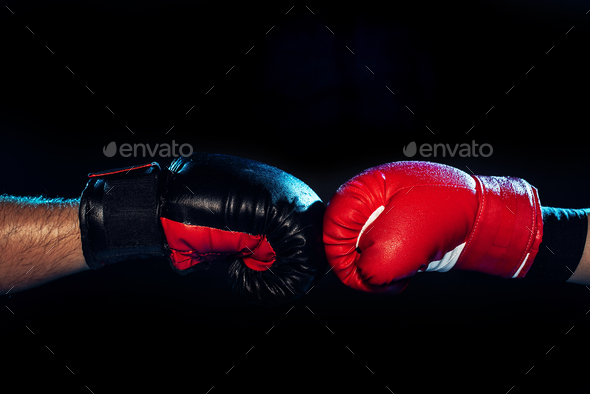 Partial view of two boxers in boxing gloves touching hands on black - Stock Photo - Images