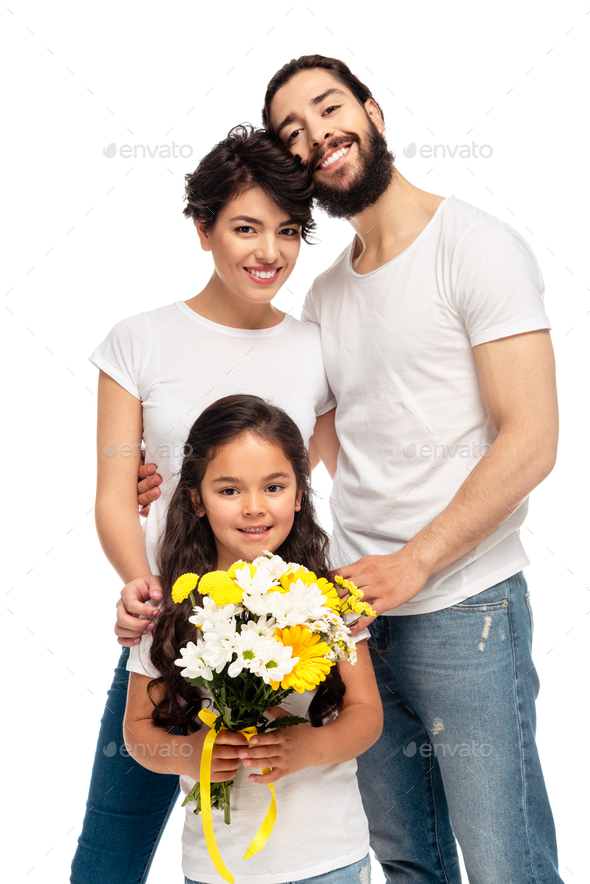 latin parents smiling near cute daughter holding flowers isolated on white