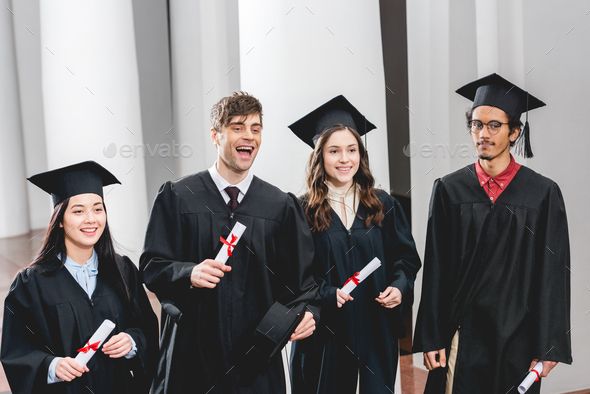 smiling group on students in graduation gowns holding diplomas Stock ...