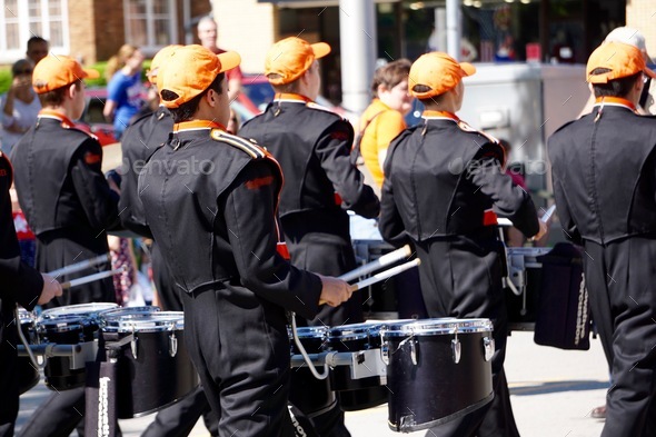 Drumline playing drums in marching band in parade