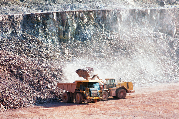 eath mover loading stones on a dumper truck. mining industries.
