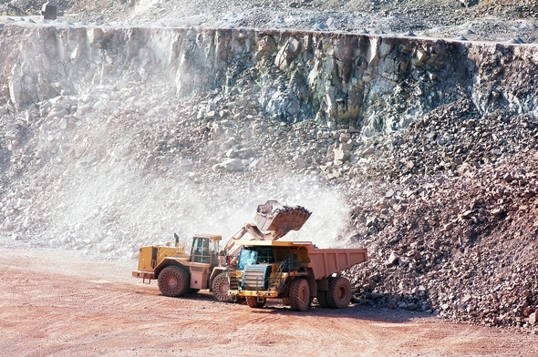 earth mover loading stones on a dumper truck. mining industries.