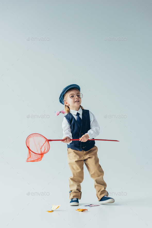adorable kid in retro vest and cap catching butterflies with butterfly net