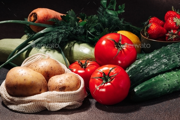 Fresh vegetables, fruits, berries and greens on a brown background still life