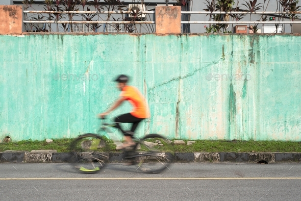 Man speeding on a bicycle with blur motion.  - Stock Photo - Images