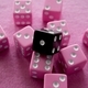 A Black Die Atop A Scattered Group Of Pink Dice On A Pink Background - PhotoDune Item for Sale