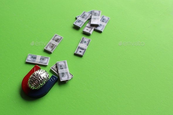 Brain and magnet attract money on green background