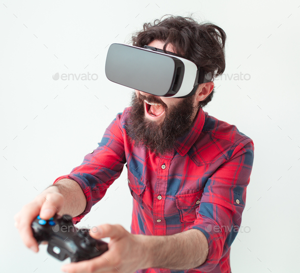 Excited man playing videogame in VR glasses. Stock Photo by kegfire