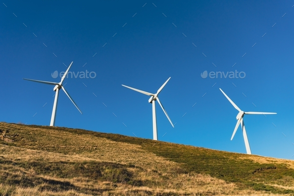 Wind turbines in a wind farm to get clean green energy through the air on top of a mountain