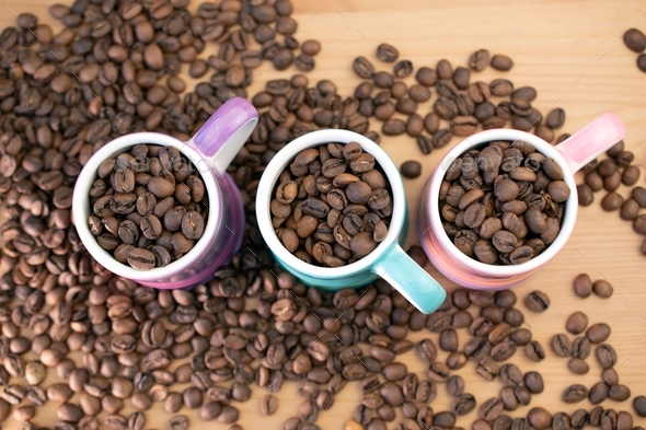 Coffee beans in cute and colorful small espresso cups Stock Photo