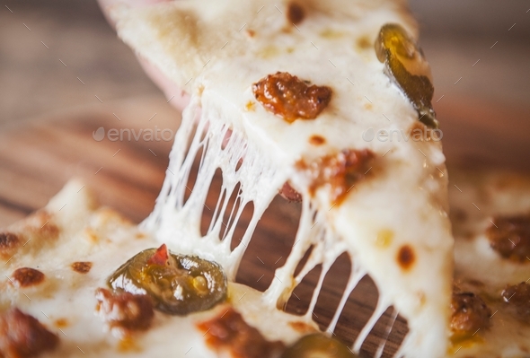 Grabbing a cheesy slice of pizza.  - Stock Photo - Images