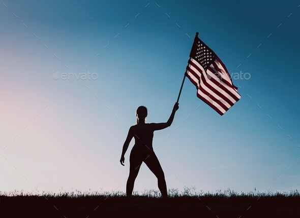 Silhouette of woman holding American flag.  - Stock Photo - Images